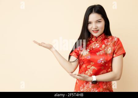 Asiatique chinois ado fille main montrer présentation vente promotion posture dressing Qipao traditionnel tissu. Banque D'Images