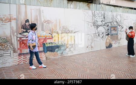 Bangkok, Thaïlande. 27 mars 2021. Une dame pose pour une photo à côté d'une peinture murale au canal d'ONG Ang. Le canal restauré offre le kayak à paddle au coeur de la ville, il a remporté un prix 2020 du Programme des Nations Unies pour les établissements humains (ONU Habitat) Asian Townscape Award. Les visiteurs peuvent pagayer des kayaks gratuitement du vendredi au dimanche à partir de 4-9 heures dans le chemin de l'eau dans Chinatown. Un trottoir pavé sur le canal offre une gamme d'étals proposant des plats thaïlandais de rue, de la musique live, des souvenirs et des vêtements. Crédit : SOPA Images Limited/Alamy Live News Banque D'Images