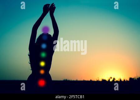 Silhouette de femme avec coeur et les mains vers le haut contre le ciel sur fond noir foncé. Placer pour le texte. Copier l'espace Banque D'Images