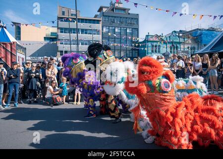 (210328) -- WELLINGTON, le 28 mars 2021 (Xinhua) -- les gens regardent un spectacle de danse du lion pendant le festival d'art et de musique de plein air CubaDupa à Wellington, en Nouvelle-Zélande, le 27 mars 2021. Le quartier de Cuba Street dans la capitale de la Nouvelle-Zélande est venu en vie au cours du week-end, tandis que les danses de lion chinois et la musique traditionnelle chinoise ornaient le plus grand festival d'art et de musique de plein air de Nouvelle-Zélande CubaDupa. L'événement a été forcé de pivoter en 2019 vers une version hors-rue en raison des tragédies de la mosquée de Christchurch, et en 2020, il a été impossible de procéder en raison des restrictions de verrouillage de la COVID-19. Cependant, le 2021 Banque D'Images