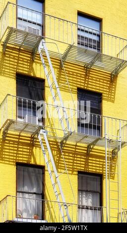 Ancien bâtiment jaune avec évacuation au feu de fer, New York City, Etats-Unis. Banque D'Images