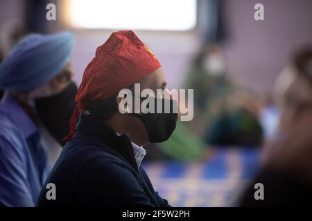 Glasgow, Royaume-Uni, le 28 mars 2021. Anas Sarwar (couverture à tête rouge), dirigeant du Parti travailliste écossais, visite le centre de Glasgow Gurdwara, le premier jour de services pour la communauté sikh depuis que les restrictions de verrouillage ont commencé à se relâcher. Sarwar a entrepris cette visite dans le cadre de la campagne pour les élections parlementaires écossaises du 6 mai. Crédit photo : Jeremy Sutton-Hibbert/Alay Live News Banque D'Images