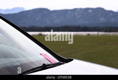 28 mars 2021, Bavière, Füssen: Un avis d'infraction administrative est collé à l'essuie-glace d'une voiture garée dans une zone de conservation du paysage. De nombreuses excursions ont été attirées au Hopfensee au soleil. Beaucoup d'entre eux sont venus en voiture. Photo : Karl-Josef Hildenbrand/dpa Banque D'Images