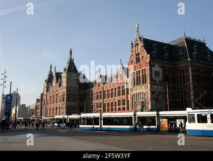 AMSTERDAM, PAYS-BAS-MARS 8 : bâtiment historique de la gare centrale d'Amsterdam et tramways d'attente de passagers .Mars 8,2014 à Amsterdam, pays-Bas. Banque D'Images
