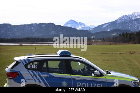 28 mars 2021, Bavière, Füssen : une patrouille de police se déplace le long d'une zone de conservation du paysage au lac Hopfen. De nombreuses excursions ont été attirées au Hopfensee au soleil. Beaucoup d'entre eux sont venus en voiture. Photo : Karl-Josef Hildenbrand/dpa Banque D'Images