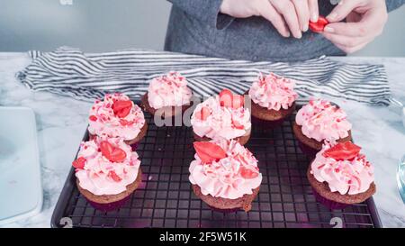 Étape par étape. Décoration des cupcakes en velours rouge avec des coeurs et des baisers rouges au chocolat. Banque D'Images