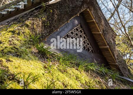 Gros plan d'un évent en treillis sur un toit de chaume traditionnel japonais en bois recouvert de mousse sur un ancien salon de thé à Nara, Japon Banque D'Images