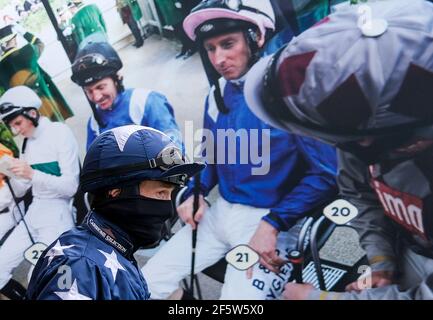 Le jockey Sam Twiston-Davies passe devant une grande photographie de jockeys sur le mur dans la salle de pesée en chemin vers l'anneau de parade de l'hippodrome d'Ascot. Date de la photo: Dimanche 28 mars 2021. Banque D'Images