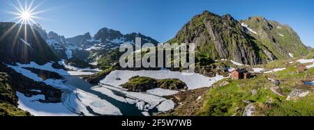 Lac Isvatnet avec glace, montagnes et neige, cabane de montagne Trollfjord Hytta, au Trollfjord, Lofoten, Nordland, Norvège Banque D'Images