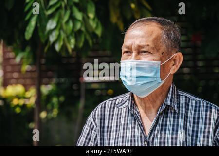 Portrait en gros plan d'un homme asiatique heureux et âgé portant un masque avec espoir. Vieil homme thaïlandais Banque D'Images