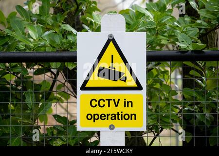 Panneau d'avertissement CCTV générique fixé à une clôture de jardin dans un endroit rural. Le signe aide à dissuader les criminels potentiels qu'ils sont enregistrés. Banque D'Images