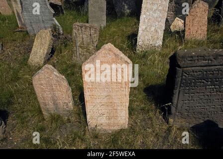 Les 12,000 pierres tombales visibles, entassées dans les murs de l'ancien cimetière juif dans le quartier juif ou Josefov de Prague, capitale de la République tchèque / Tchéquie, cachent 100,000 anciens sépultures dans jusqu'à 12 niveaux souterrains. Le cimetière a été utilisé pendant près de 350 ans et, lorsque les couches ont été montées, quelques pierres tombales anciennes ont été soulevées à la nouvelle surface. Les premiers portent uniquement des inscriptions hébraïques, mais les exemples suivants comportent des symboles qui font allusion au nom, au caractère ou à la profession du défunt. Banque D'Images