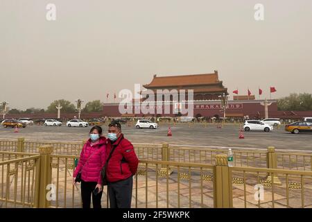 Pékin, Chine. 28 mars 2021. Les gens portent des masques pour visiter le site pittoresque de Tiananmen à Pékin, entouré de tempêtes de sable.UNE épaisse brume descend sur Pékin alors qu'une tempête de sable couvre la ville. L'observatoire national de la Chine a émis une alerte jaune pour les tempêtes de sable dans la partie nord du pays. Crédit : SOPA Images Limited/Alamy Live News Banque D'Images