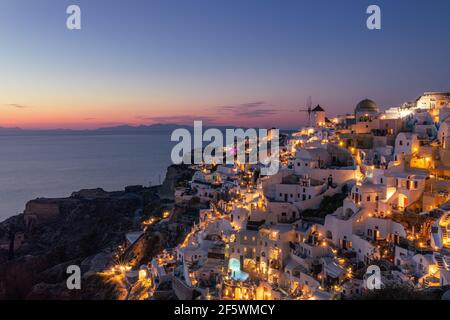 Vue imprenable sur l'île de Santorini en soirée. Pittoresque coucher de soleil sur le célèbre village de Fira, Grèce, Europe. Présentation du concept de déplacement. Artistique Banque D'Images