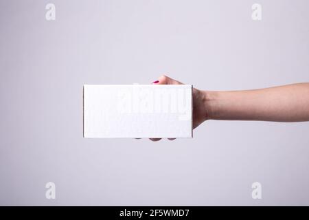 boîte en carton blanc dans les mains des femmes. vue latérale, livraison, emballage, commande Banque D'Images