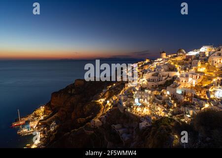 Vue imprenable sur l'île de Santorini en soirée. Pittoresque coucher de soleil sur le célèbre village de Fira, Grèce, Europe. Présentation du concept de déplacement. Artistique Banque D'Images