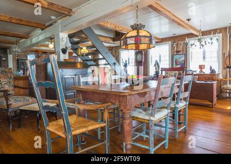 Table à manger en bois de pin teinté brun antique avec peint en vieilli chaises de siège en bois bleu rasé dans la salle à manger avec large parquet en pin Banque D'Images