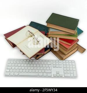 Clavier Apple et livre vintage Old English poème sur blanc arrière-plan Banque D'Images