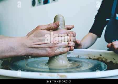 De belles mains de femmes au-dessus de la roue de potier. Sculptez de l'argile dans un atelier de poterie. Poterie traditionnelle. Concept d'atelier de céramique Banque D'Images