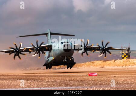 CEFN SIDAN, PAYS DE GALLES - MARS 25 2021: Un avion de transport militaire de la Royal Air Force Airbus A400M 'Atlas' pratiquant des atterrissages tactiques sur une plage Banque D'Images