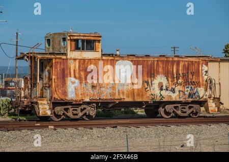 Un caboose rouillé sur une piste au bord de la route à Lompoc, Californie. Banque D'Images