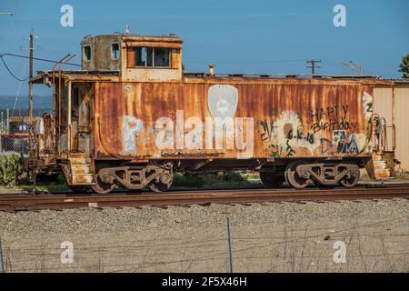 Un caboose rouillé sur une piste au bord de la route à Lompoc, Californie. Banque D'Images