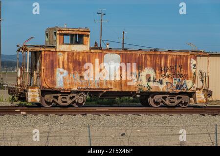 Un caboose rouillé sur une piste au bord de la route à Lompoc, Californie. Banque D'Images