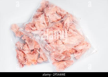 Dos de poulet crus dans un emballage emballé dans une boîte pour livraison sur fond blanc isolé, vue latérale. Boîte de viande crue pour supermarché, vente au détail. Banque D'Images