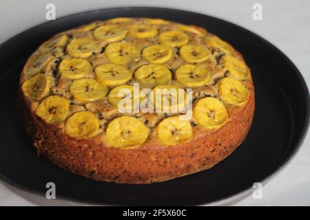 Gâteau de plantain fait maison avec des tranches de plantain comme garniture. Prise de vue sur fond blanc. Banque D'Images