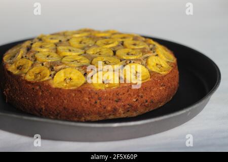 Gâteau de plantain fait maison avec des tranches de plantain comme garniture. Prise de vue sur fond blanc. Banque D'Images