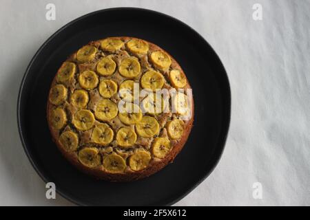 Gâteau de plantain fait maison avec des tranches de plantain comme garniture. Prise de vue sur fond blanc. Banque D'Images