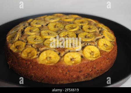 Gâteau de plantain fait maison avec des tranches de plantain comme garniture. Prise de vue sur fond blanc. Banque D'Images