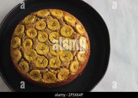 Gâteau de plantain fait maison avec des tranches de plantain comme garniture. Prise de vue sur fond blanc. Banque D'Images