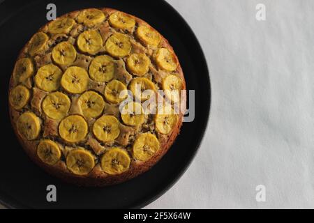 Gâteau de plantain fait maison avec des tranches de plantain comme garniture. Prise de vue sur fond blanc. Banque D'Images