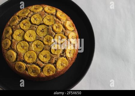 Gâteau de plantain fait maison avec des tranches de plantain comme garniture. Prise de vue sur fond blanc. Banque D'Images