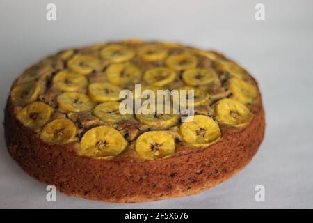 Gâteau de plantain fait maison avec des tranches de plantain comme garniture. Prise de vue sur fond blanc. Banque D'Images