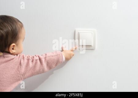 Petit enfant jouant avec le commutateur Banque D'Images