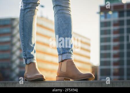 Jambes de femme en Jean et chaussure en cuir. Femme tendance portant des vêtements décontractés en ville. Banque D'Images