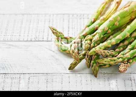 Asperges. Bouquet d'asperges vertes fraîches prêtes à cuire sur fond blanc en bois ancien. Espace de copie de la vue de dessus. Banque D'Images