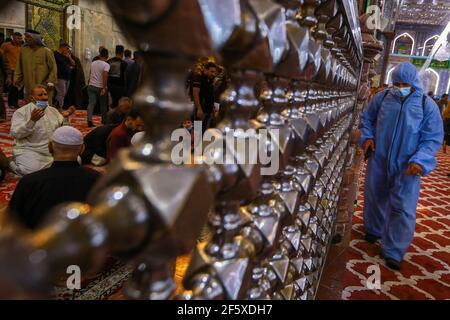 Karbala, Irak. 28 mars 2021. Un agent de santé désinfecte le sanctuaire de l'Imam Husayn lors des célébrations du Nisf de Chaban (Mid-Sha'ban). L'événement se tient dans la nuit entre le 14 et le 15 de Sha'aban, qui est le huitième mois du calendrier islamique, pour commémorer la naissance du dernier Imam chiite Muhammad al-Mahdi, Selon les musulmans chiites, qui est censé émerger avant la fin des temps pour apporter la paix et la justice au monde. Credit: Ameer Al Mohmedaw/dpa/Alamy Live News Banque D'Images