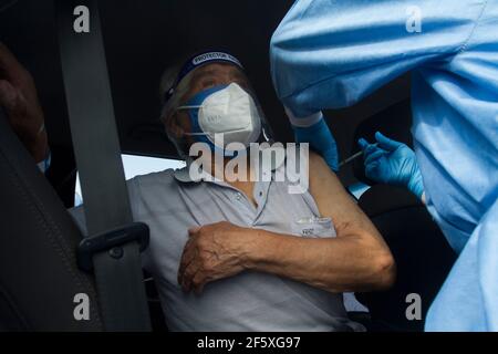 Un homme âgé reçoit la première dose du vaccin Pfizer contre Covid-19 au Vaccine car Centre Parque de las Leyendas. La Vaccine car est une procédure dans laquelle les gens sont vaccinés contre Covid-19 à l'intérieur de leur propre voiture. Il a été conçu pour aider les personnes âgées, en particulier celles qui ont des difficultés à marcher et à se mobiliser. Le gouvernement péruvien a commencé le processus de vaccination à partir de personnes de plus de 85 ans. À ce jour, 525,301 péruviens ont été vaccinés contre Covid-19. Lima, Pérou. Banque D'Images