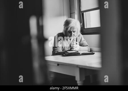 Vieille femme passant du temps seul avec dieu, priant et lisant la bible. Banque D'Images