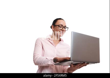 Jeune femme joyeuse souriant regardant l'appareil photo sur un fond blanc avec un ordinateur portable dans ses mains. Copier l'espace Banque D'Images