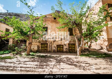 Aouli, Maroc - 10 avril 2015. Portes rouillées vertes de maison abandonnée, partiellement enterrées de sable Banque D'Images