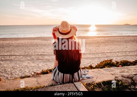 Une jeune femme bronzer au coucher du soleil sur une plage dans le sud Espagne Banque D'Images