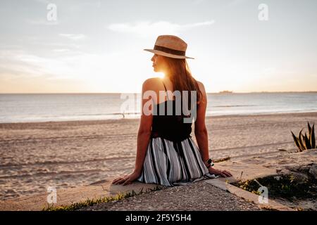 Une jeune femme bronzer au coucher du soleil sur une plage dans le sud Espagne Banque D'Images