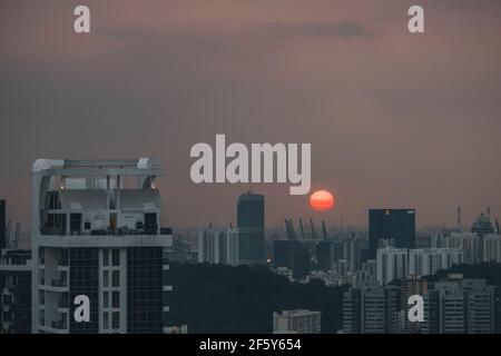 Coucher de soleil derrière les grands bâtiments de Singapour paysage urbain contre ciel nuageux au coucher du soleil. Banque D'Images