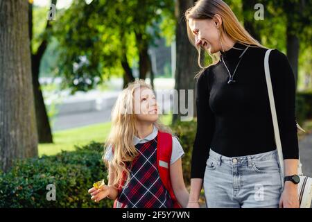 une jeune fille d'âge préscolaire marche avec sa mère Banque D'Images