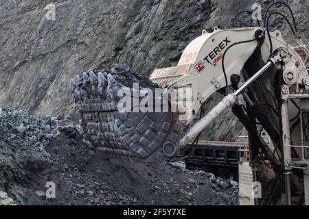 Rudny/Kazakhstan - Mai 14 2012 : extraction de minerai de fer à ciel ouvert en carrière. Pelle hydraulique Terex chargeant le minerai dans le train de cargaison. Gros plan. Banque D'Images