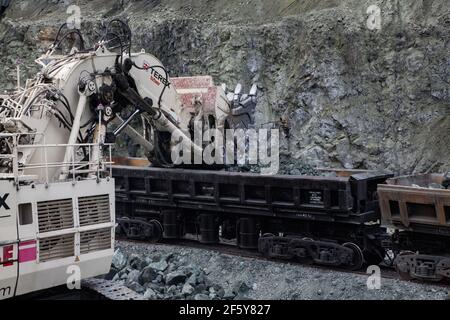 Rudny/Kazakhstan - Mai 14 2012 : transport du minerai sur une usine de concentration. Pelle hydraulique Terex chargement de minerai de fer dans un wagon exploitation minière à ciel ouvert (carrière). Banque D'Images